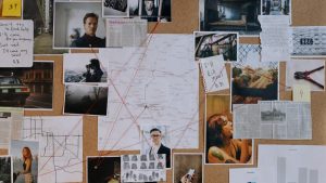 A detailed crime investigation board filled with photos, maps, and red strings connecting clues and evidence.